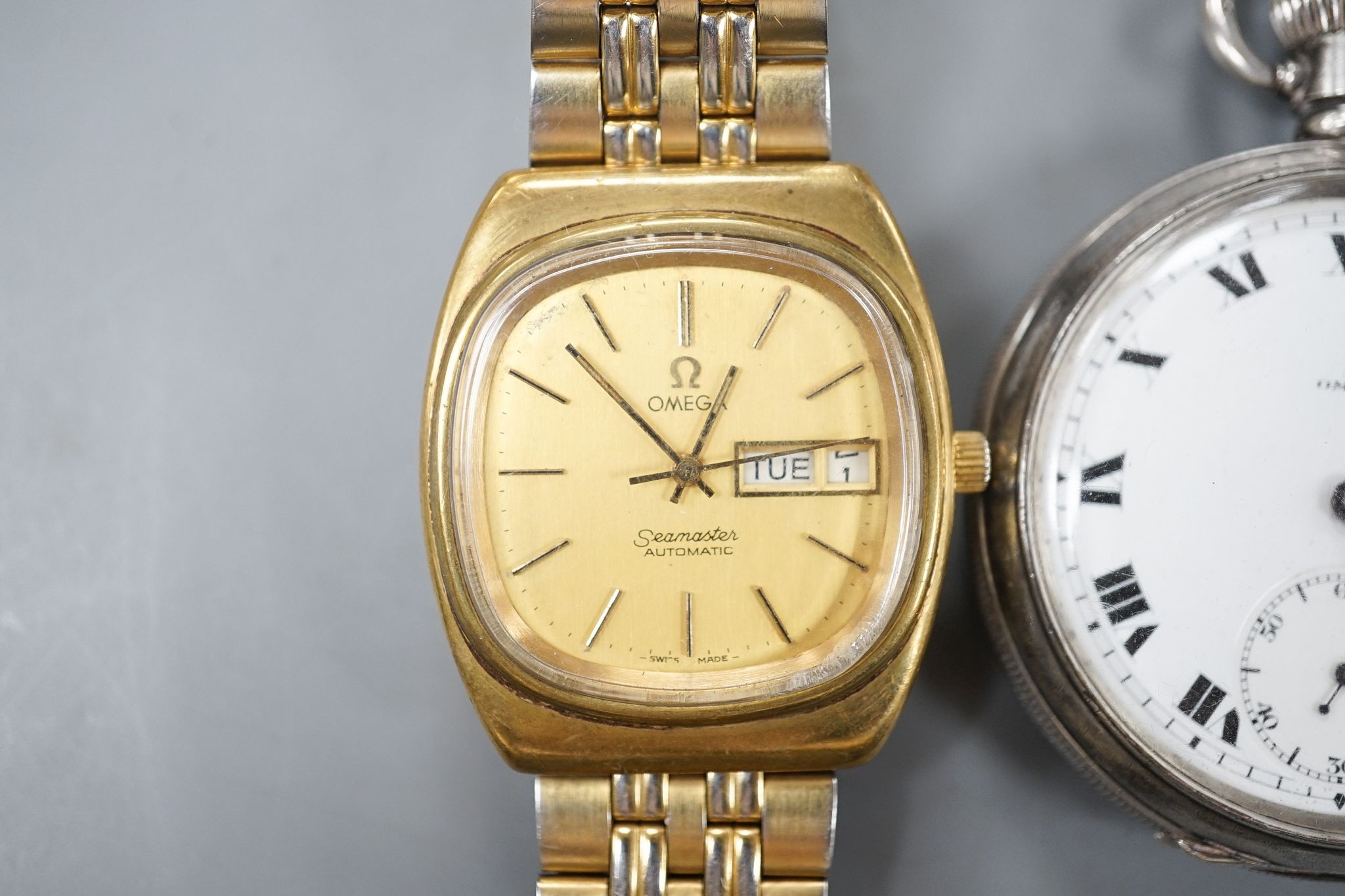 A George V silver Omega open face keyless pocket watch and a gold plated Omega Seamaster day/date automatic wrist watch.